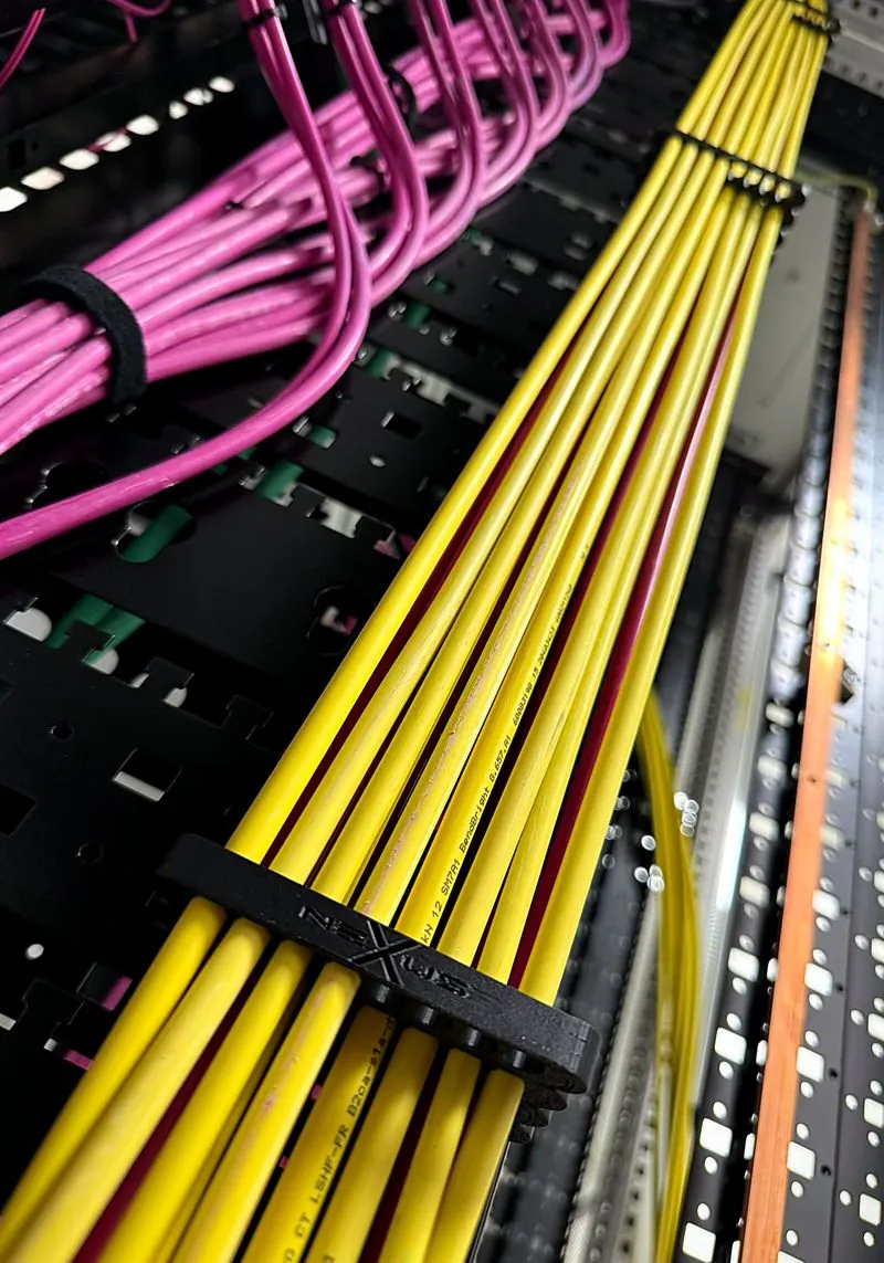 Fiber cabling in a data center, yellow cables neatly held by a Nexus-branded comb